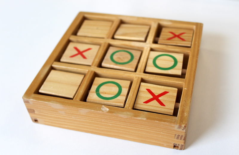 Wooden noughts and crosses board with rotating pieces