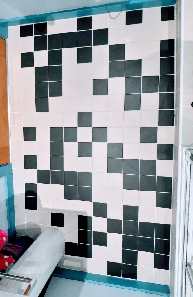 Photograph of a bathroom floor covered in black and white square tiles