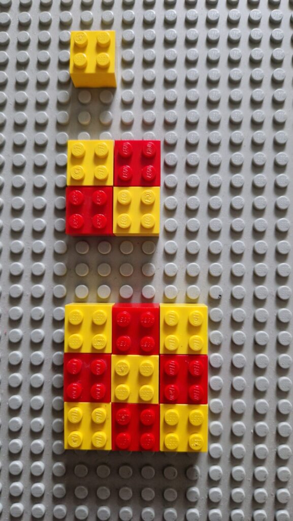 An overhead view of three patterns made from square red and yellow lego bricks: the first is a single yellow square, the second has yellow-red on the top row and red-yellow on the bottom, and the third has three rows: yellow-red-yellow on top, red-yellow-red in the middle, yellow-red-yellow on the bottom.