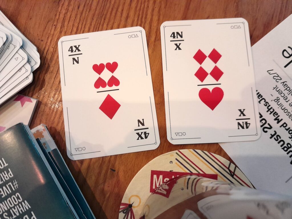 The cards (4X)/N and (4N)/X arranged on the table in a pub