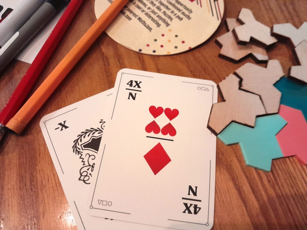 The cards -X and (4X)/N arranged on the table in a pub