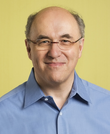 Photo of Stephen Wolfram, a balding white man with glasses and a blue shirt