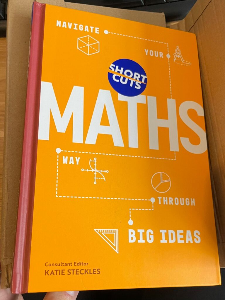 Photo of the book, which is orange and says 'Short Cuts: Maths' on the front, with some mathematical illustrations and the words 'Navigate Your Way Through Big Ideas'