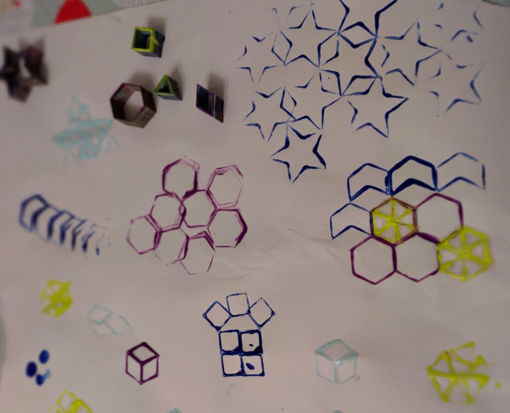 Lots of shapes printed in several colours on a big piece of paper. There are stars, hexagons, chevrons, squares, triangles and lozenges. The stampers are at the top of the page.
