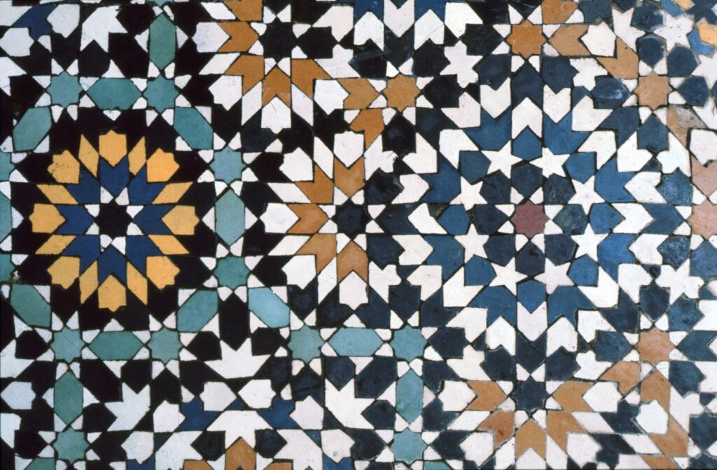 A colourful mosaic tiling made of several kinds of irregular shapes, with several eight-pointed stars surrounded by five-pointed stars.