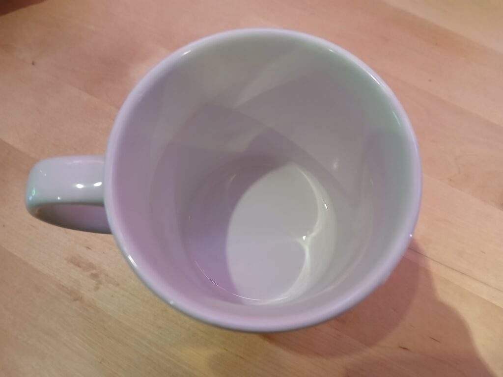 Empty tea cup with light pattern in the bottom showing a cardioid curve