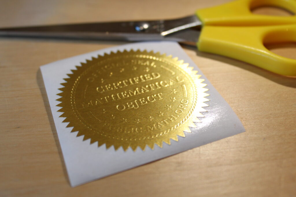 Gold embossed sticker which says Certified Mathematical Object Official Seal Public-Math.org