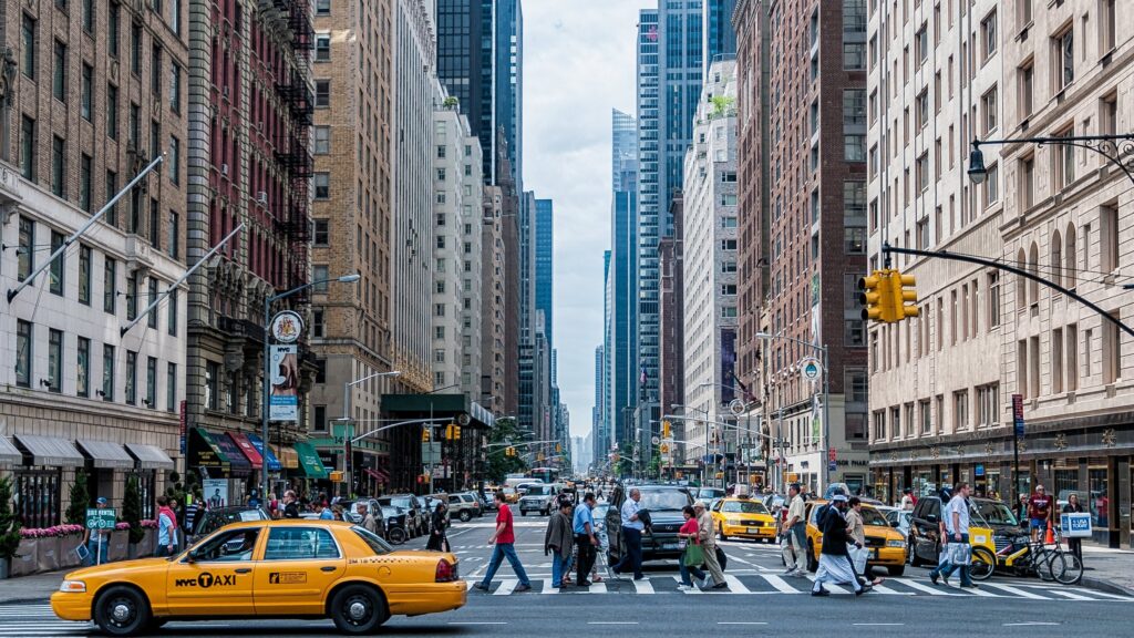 Yellow taxi on a busy city street.